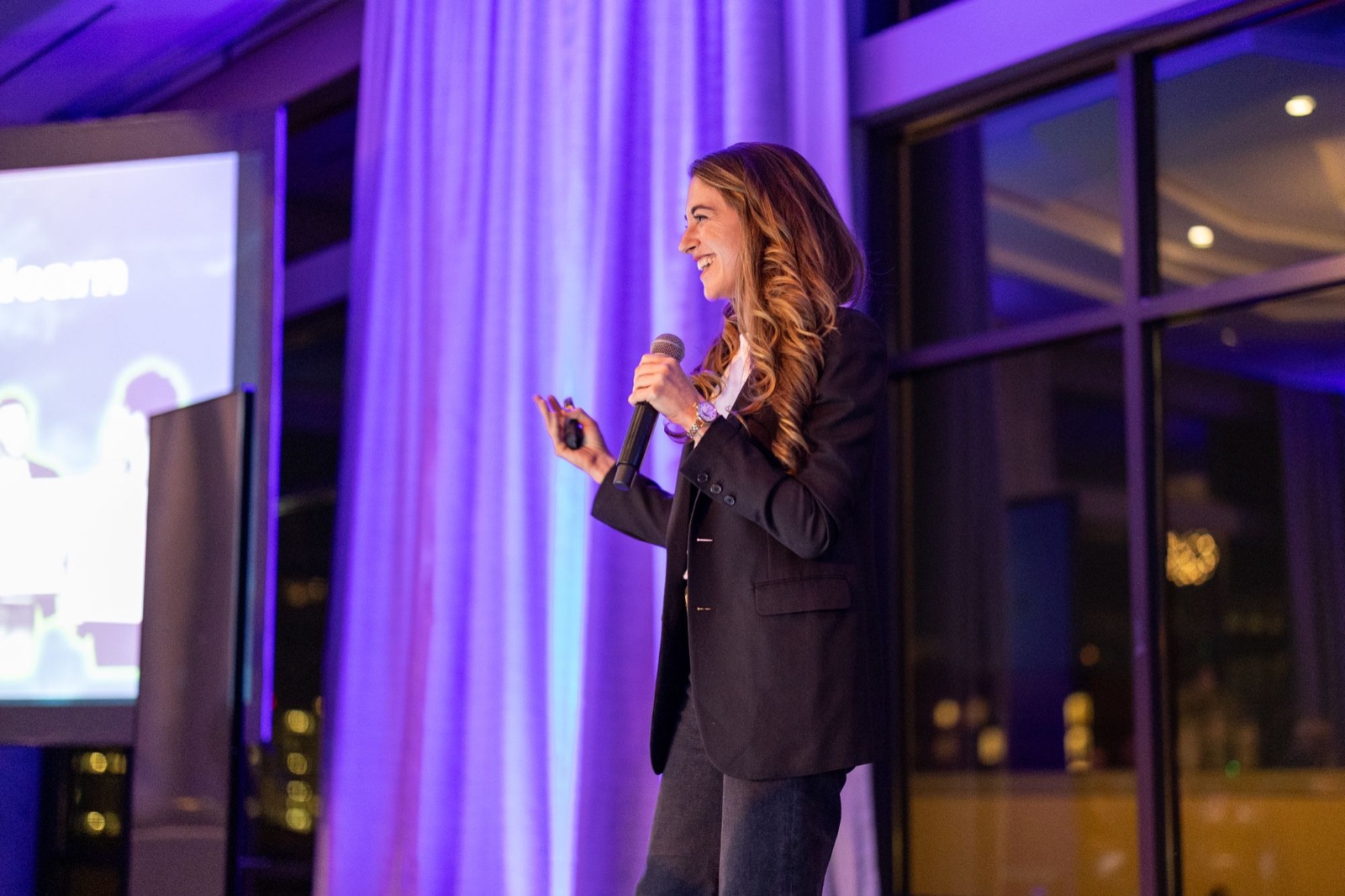 Kristin Messerli on stage with a microphone.